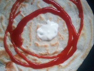 8、风味杂粮煎饼果子,翻面，挤上调味酱和沙拉酱。