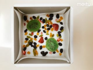 1、什锦果干酸奶糕,在模具里铺上油纸，撒上果干，我用了猕猴桃干、黄桃干、黑加仑葡萄干、葡萄干、冻干草莓脆，可以根据自己的喜好和手边的材料调配