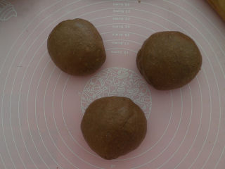 8、可可麻薯夹心软欧,我们将发酵好的面团取出排气揉匀。分割成3等份，盖上保鲜膜静置15分钟