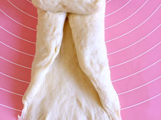 8、羊奶吐司,左右两侧向上翻折,然后自上而下卷起,收口压薄捏紧。