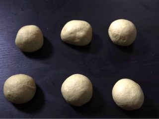 5、抹茶豆大福软欧,将一次发酵后的面团分成6等份。将面团重新团成团后,缝口,盖上湿毛巾,醒面(十分钟)