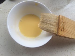 19、黄油面包卷,准备一点蛋黄，加一半水搅匀。