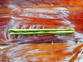 11、即方便又快捷~一次发酵双色绣球馒头,取其中一份绿色面团，搓成长条，再对折！