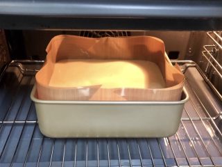 11、软软嫩嫩入口即化的古早蛋糕‼️（抖臀蛋糕⁉️）,在桌子上振出大气泡，放进提前预热好的烤箱中，上下火150度，烤60分钟。（我不喜欢把模具直接放进水中，像这种方法放在烤架上也是能达到同样效果的）