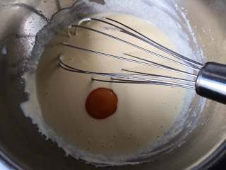 4、空气感轻乳酪蛋糕,分两次加入蛋黄，将蛋黄糊搅拌均匀