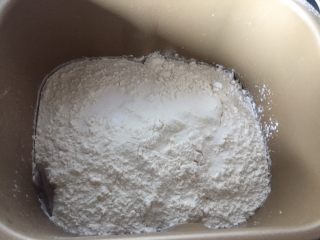 2、双色梅花吐司,所有材料除黄油和酵母放进面包桶启动揉面程序，冬天酵母可以和面粉一起放。