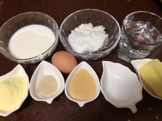 2、一次发酵吐司面包,所有配料也都称好备用，牛奶、白糖、清水、奶粉、鸡蛋、酵母粉、炼奶、盐，黄油