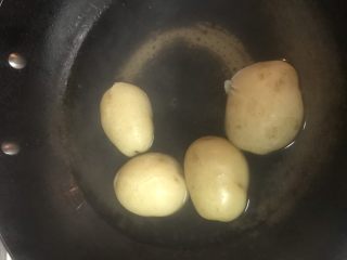 3、可乐饼,土豆洗净放入锅内煮熟。用筷子可以轻松插过就代表熟了。
