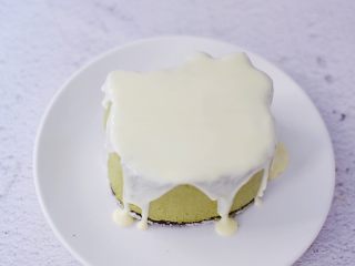 17、4寸KT猫抹茶慕斯蛋糕,把白色巧克力隔水融化，然后慢慢淋上慕斯蛋糕表面，放入冰箱冷藏备用