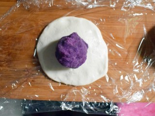 13、紫薯烧饼,去一个面剂子用手压成饼状，放上一个紫薯丸子。