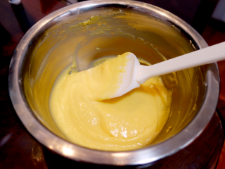 6、酸奶戚风纸杯蛋糕,用刮刀搅拌均匀，呈顺滑状，千万不要画圈，容易消泡，要从底部往上翻拌，蛋黄糊就好了；