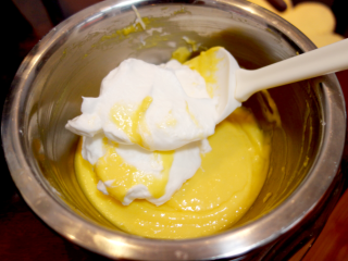 9、酸奶戚风纸杯蛋糕,取三分之一蛋白加入蛋黄糊里，翻拌均匀，不要画圈；