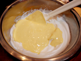 10、酸奶戚风纸杯蛋糕,把翻拌好的蛋黄糊全部倒入蛋白里，翻拌均匀，所有的翻拌都不要画圈，容易消泡，把最后的蛋糕糊倒入纸杯里，9分满，用裱花袋或直接用刮刀装都可以哈；