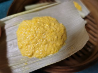 11、黄金玉米饼,将搅拌均匀的玉米糊用勺子盛放到玉米叶子上。