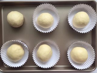 4、劲脆汉堡包,将发酵好的面团拿出来，放在揉面垫上，进行按压排气，排气好后，均匀分成六份并且滚圆