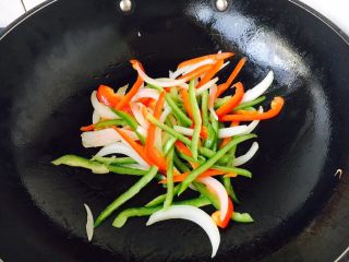 3、上班族的最爱 快手 黑胡椒意面,锅里放适量的玉米油，油温热后先炒洋葱，当洋葱炒出香味，再放入青红椒丝，翻炒两下，盛盘备用。