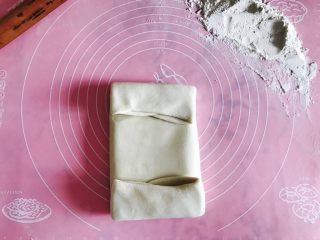 15、自制酥皮版蛋挞,左折一下 包住黄油 右折一下包住 然后把上下多出来的折好。像叠被子一样 压实!压的时候把气泡排出