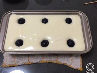 13、紫葡萄玉枕蛋糕,吐司盒底部放一张烤盘纸,便于脱模,蛋糕糊倒入吐司盒震几下,葡萄放入表面,马上送入烤箱烤制,动作要快,葡萄会沉底的。