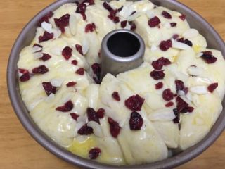 11、蔓越莓面包,面团上刷上剩下的炼乳黄油酱和蔓越莓干，再放上些杏仁片