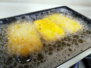 9、江南名小吃～炸年糕,转中小火，把年糕片放进锅里，炸至两面金黄色