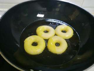 3、甜甜圈,锅里倒入足量油，烧热约七成热时放入甜甜圈油炸。