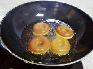 4、甜甜圈,二十秒钟左右变色后翻一面继续炸另一面，注意火候太大容易炸糊掉，太小容易吃油。