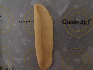 5、汉堡热狗,静置好后，取一个面团擀成长片，然后由左往右卷起，收口处一定要捏紧