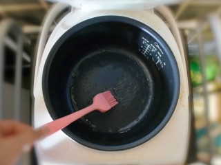 11、奶香葡萄干小面包（电饭锅版）,将电饭锅的底部和侧面，用刷子刷一层油。