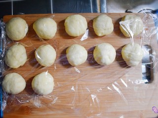 10、奶香葡萄干小面包（电饭锅版）,分成12个大小的面剂子，并用保鲜膜盖住，备用。