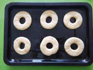 1、甜甜圈,将多余面块再次揉成面团，擀成面皮，压出模型。将做好的甜甜圈面团洒上面粉防止粘黏。烤盘涂抹一层油，将甜甜圈放到烤盘上。