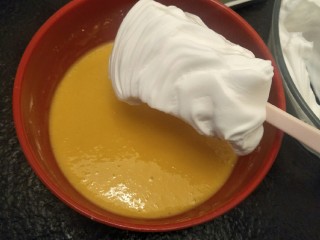 17、绵软细腻戚风蛋糕,挖一勺蛋白加入蛋黄中翻拌均匀。