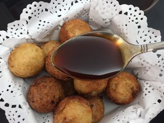 22、章鱼小丸子,然后将做好的章鱼小丸子放入油纸碗中，淋入烧汁