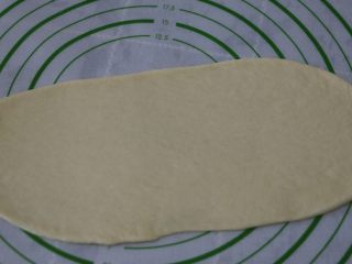 8、椰丝排包,取一块面团擀成长椭圆,长度尽量长一点,比烤盘短6cm就好