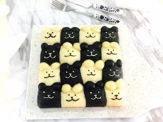 18、黑白小熊挤挤包,面包自然冷凉后，用原色奶油霜和加了竹炭粉的黑色奶油霜在面包挤出眼睛、嘴巴和鼻子。  