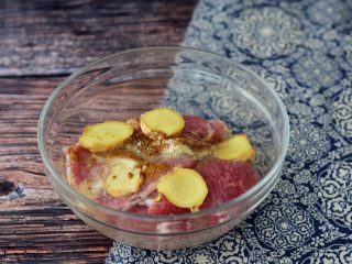 3、黄金猪排,将里脊肉片放入容器中，加入姜、料酒、味极鲜酱油、五香粉、胡椒粉、花椒粉、椒盐粉、孜然粉、鸡精、盐抓匀盖上保鲜膜放入冰箱冷藏腌制一夜