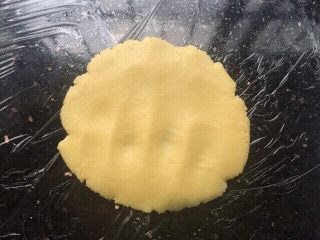 12、菠萝包,菠萝皮放操作台上手掌轻轻按压薄，压至能包下整个面团。