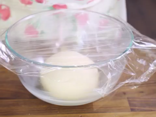 5、火腿芝士面包,在碗内抹上黄油，面团放入，盖上保鲜膜发酵1-2小时，直至面团发至两倍大