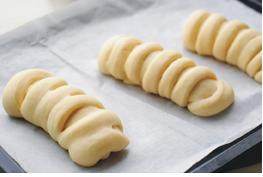 12、毛毛虫面包,依次将所有面包整形好，间隔摆入烤盘，放在温暖处二次发酵约2倍大；