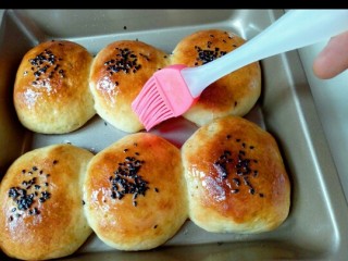 12、蜜豆小面包,戴上隔热手套取出烤盘，立即刷上一层玉米油，这样会更好的锁住水份。