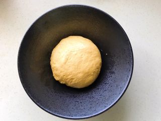 6、胡萝卜拉丝芝士餐包,取出搓圆放在碗里，包保鲜膜发酵，现在室温发酵就可以了，天气冷可以开启烤箱发酵功能