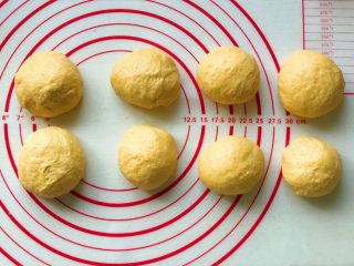 8、胡萝卜拉丝芝士餐包,平均分成八份，搓圆盖保鲜膜松弛10分钟