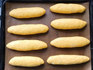 15、胡萝卜拉丝芝士餐包,依次码入烤盘中，放进烤箱进行二次发酵，天气热不用开启发酵功能，常温就可以了