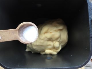 4、牛角包,把面团放回面包桶，加入盐和面，揉5分钟左右，盐差不多被面团吸收了。