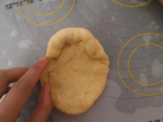 7、汉堡热狗,然后在取一个面团擀成圆片，然后由上而下的 将面皮往内卷（如图）