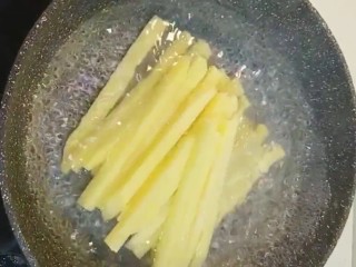 3、炸薯条,水开下锅煮两分钟捞出控干水分