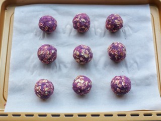 9、紫薯燕麦饼,取适量紫薯泥，搓成小球，放在铺了烘焙纸的烤盘上。