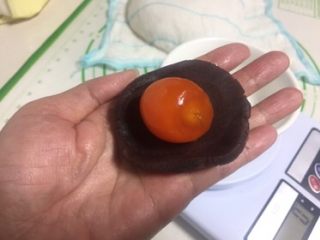 8、豆沙蛋黄酥,豆沙捏成圆片，蛋黄放在中间，豆沙把蛋黄包起来搓圆。