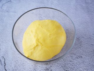 6、南瓜吐司,把揉好的面团取出放入容器中,盖上保鲜膜进行一发