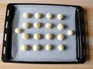 7、蛋白椰丝球,揪一小团揉成圆球形，一一放在铺了油纸的烤盘上;