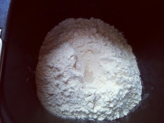 4、蔓越莓吐司面包,最后放入面粉，再面粉顶端挖个小洞，注意不要挖到液体。把酵母粉放入洞里，再用周边的面粉把酵母粉盖起来。